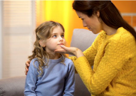 little girl is being comforted by her mother