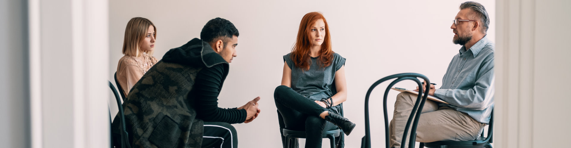 psychotherapist talking to rebellious teenagers with alcohol addiction during rehab